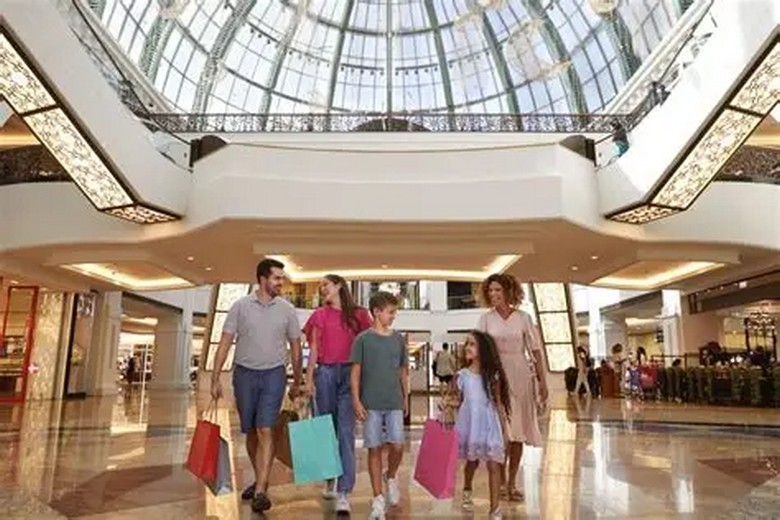 Gia đình nhiều thế hệ tham quan trong trung tâm thương mại Dubai Mall có điều hòa mát mẻ