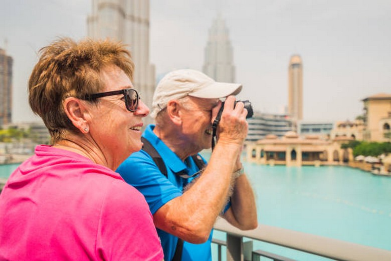  Người lớn tuổi đội mũ, đeo kính râm tham quan ngoài trời ở Dubai vào mùa mát