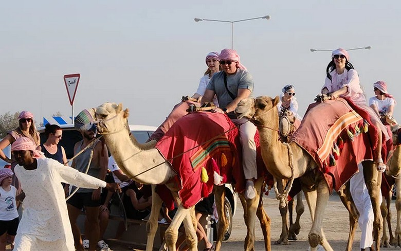 Đoàn khách mặc trang phục dài tay, đội khăn khi trải nghiệm desert safari trên sa mạc