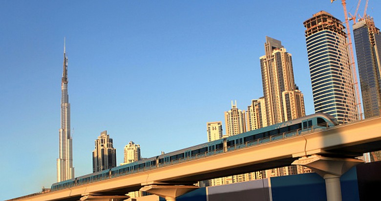 Tàu điện Metro Dubai chạy trên cao với tháp Burj Khalifa phía xa