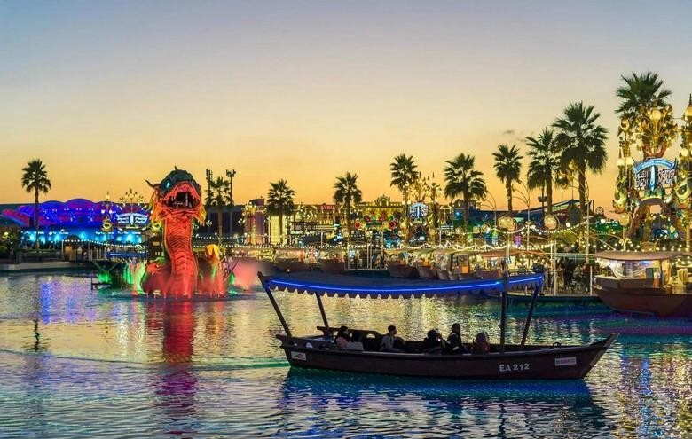 Thuyền abra chở khách qua sông Dubai Creek buổi tối, phía sau là chợ Vàng lên đèn