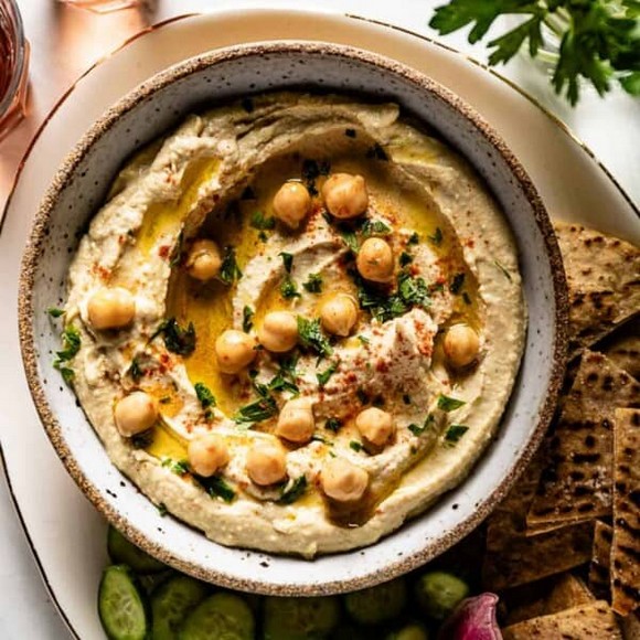 Đĩa hummus rưới dầu ô liu và rắc hạt thông