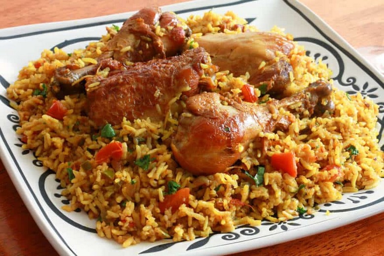 Một đĩa Machboos gà lớn bày cùng hành phi và hạnh nhân rang