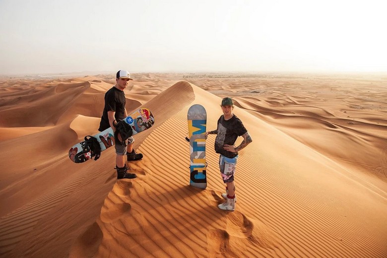 Khách trượt cát trên ván sandboard giữa đồi cát vàng ở Lahbab