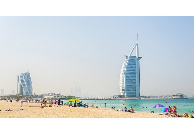 Bãi biển Jumeirah với hàng ghế tắm nắng và khách sạn Burj Al Arab phía xa