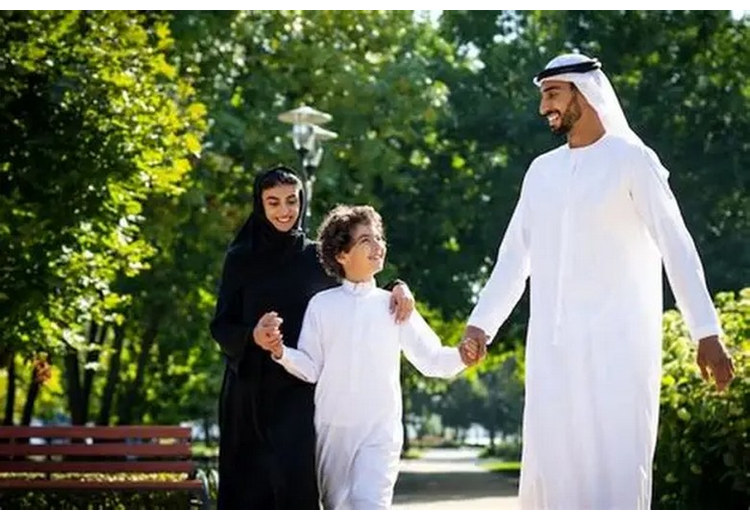 Cha mẹ nắm tay con nhỏ đi dạo trong khu vui chơi an toàn ở Dubai
