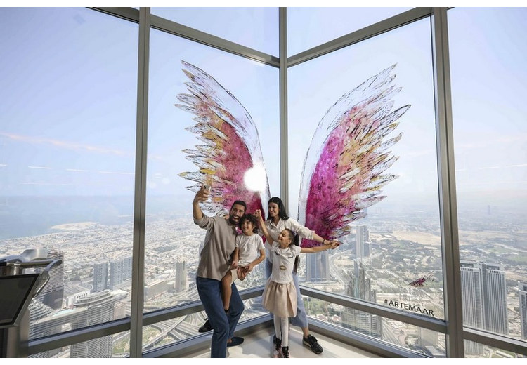 Gia đình nhiều thế hệ chụp ảnh bên cửa kính sát sàn trên đài quan sát Burj Khalifa