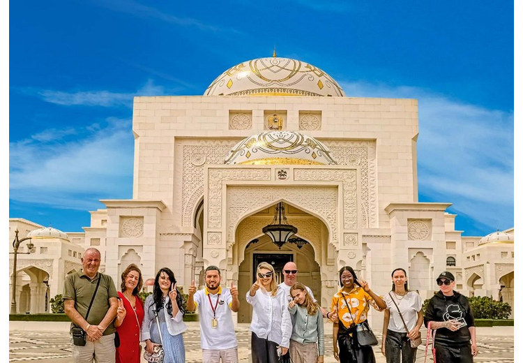 Khách tham quan chụp ảnh trước mặt tiền đá cẩm thạch trắng của Qasr Al Watan