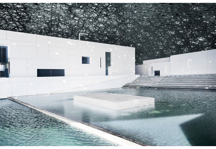 Sân trong Louvre Abu Dhabi với ánh sáng lấp lánh đổ xuống mặt nước